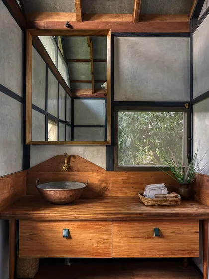 The bathroom vanity, crafted from a single piece of live-edge wood and paired with a hammered copper sink. This detail shows my commitment to handcrafted, unique elements even in a prefab design.