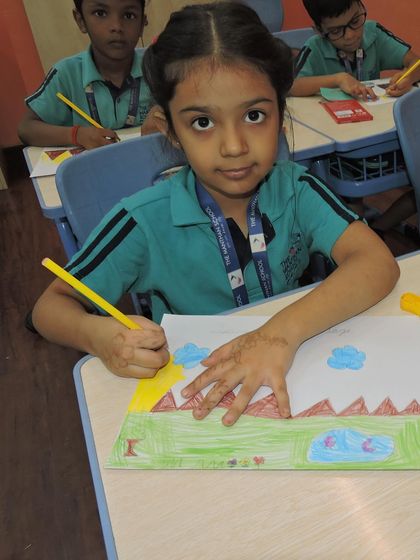 A student carefully draws a landscape, using her imagination to bring the story she heard to life on paper.
