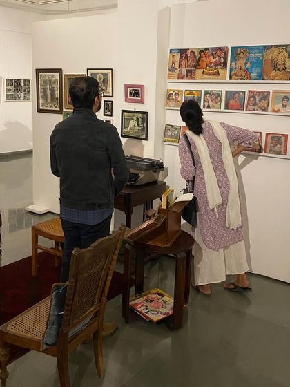 Visitors examining the vintage LP record covers displayed on the wall.