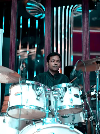 Another shot of our drummer, focused and in the zone. The drum kit is essential for driving the energy during our live fusion performances.