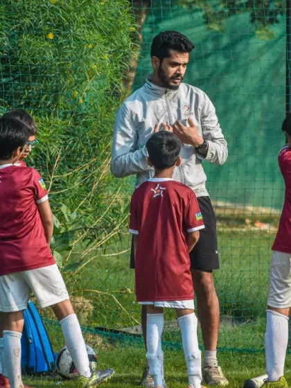 Clear communication is key. A coach explains a drill to his young players, ensuring they understand their roles and the objective of the exercise.