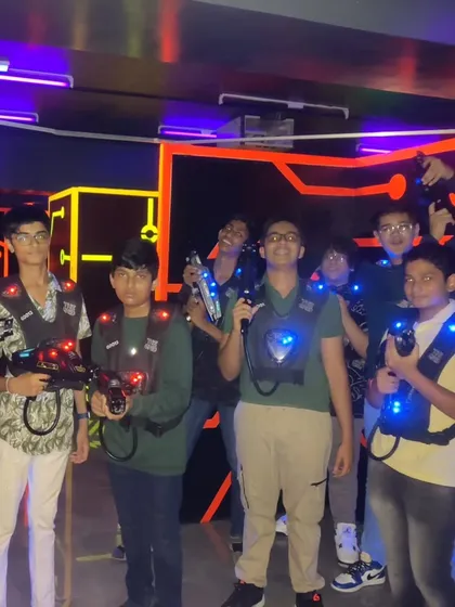 A group of kids geared up and excited for their laser tag battle.