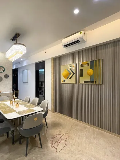Another angle of the dining area, showing the fluted wall paneling and modern art pieces. These elements add texture and color, creating a sophisticated and visually engaging environment.