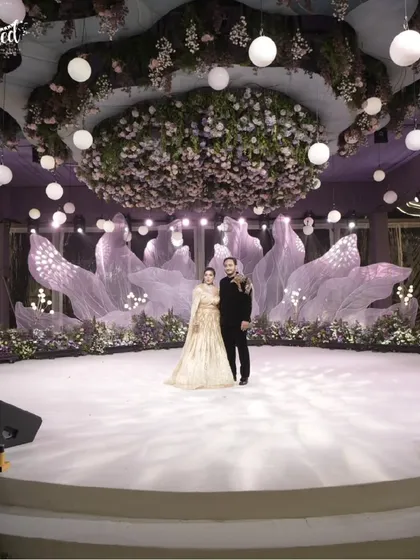 A stage set for forever. For this elegant engagement, I designed a dreamy, romantic backdrop with ethereal fabrics and a breathtaking floral canopy. It’s all about creating a magical space where your love story can take center stage.