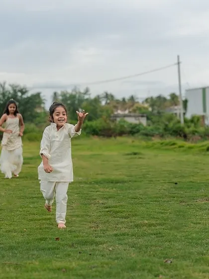 A dynamic action shot of two kids running freely and joyfully across a lawn. We let children lead the way in our outdoor shoots, ensuring we capture their natural energy and spirit.