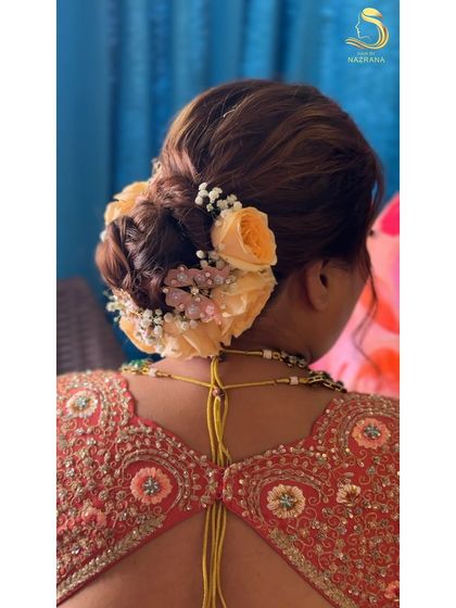 A close-up of the textured bun with roses and butterflies, a truly unique bridal style.