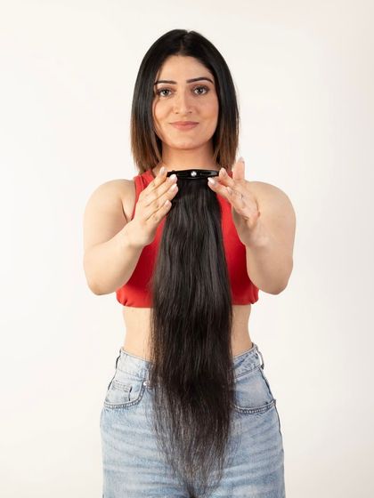A model demonstrating how to attach a ponytail hair extension.