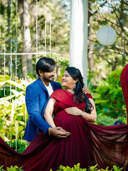 A romantic couple's maternity portrait in a beautiful garden gazebo. The flowing fabric of the gown and the loving gaze between the couple create a truly cinematic and timeless feel.