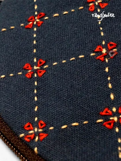 The fine craftsmanship of our artisans is visible in every stitch. This intricate floral pattern is embroidered by hand, making each pouch a unique piece of functional art.