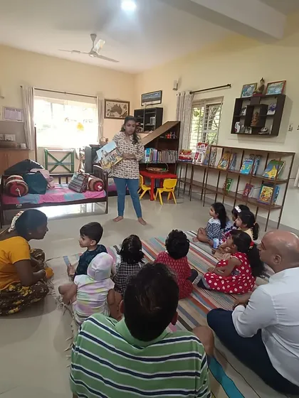 A wide view of a story session in progress, showing children and parents enjoying the tale together. Our library is a space for the whole family.