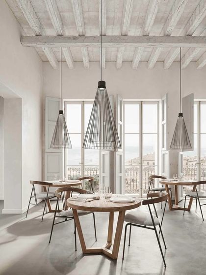 Ikonika pendants in a bright and airy restaurant setting. Their lightweight appearance is perfect for spaces with large windows and high ceilings, adding a touch of design without obstructing the view.