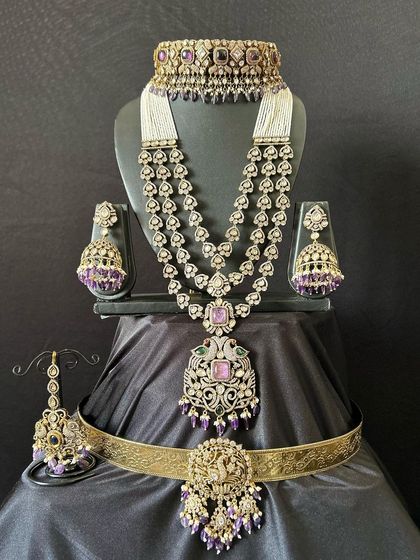 A full view of the purple Victorian bridal set. This rental includes the choker, long necklace, jhumkas, maang tikka, and a matching vaddanam with a deity motif.