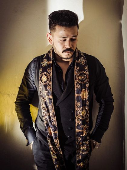 A portrait of a man with a distinct sense of style. I used hard, directional light to create strong shadows and highlight the textures of his designer outfit, resulting in a moody and confident male portrait.