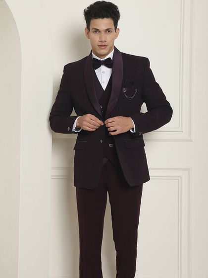 A full-length view of a model in a deep wine-colored tuxedo. This is a great option for a cocktail or reception, offering a touch of color to formal wear.