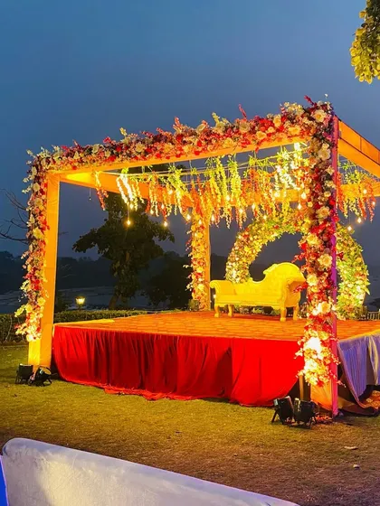 The outdoor ring ceremony mandap at dusk, with the lights beginning to glow, creating a warm and inviting ambiance.