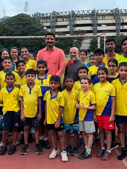 Our entire club, from the youngest kids to senior athletes, with Dr. Manoj Reddy, Sports Director of the University of Mumbai. We are a community dedicated to coaching excellence and athletic development.