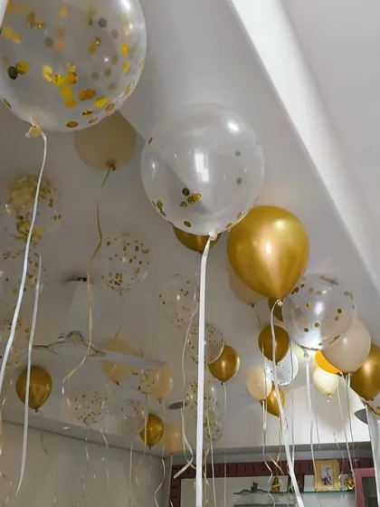 A close-up of the confetti and gold helium balloons. This is a simple and effective way to make any room feel festive and celebratory.