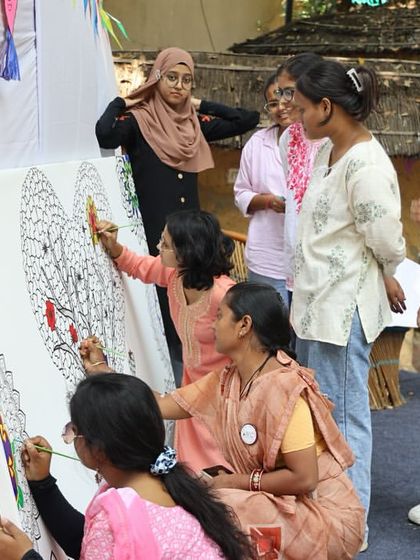 Art in action at the Bal Utsav. Participants collaborate on a large canvas, showcasing the creative and community-building spirit of the festival.