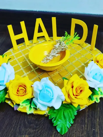 Brighten up your Haldi ceremony with this custom-made Haldi platter. The vibrant yellow theme, complete with a decorative bowl and surrounded by yellow and blue roses, is designed to bring a festive and traditional feel to the celebration.