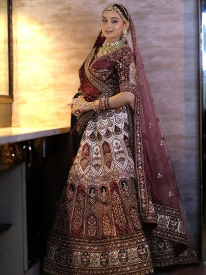 Another angle of the maroon velvet bridal look, showing the intricate embroidery of the lehenga and how the jewellery complements its design.