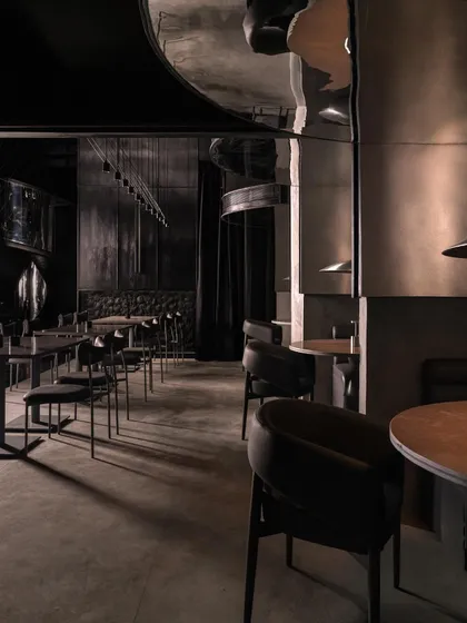 A wide view of the dining area, showing the relationship between the different seating types and the overall architectural language.