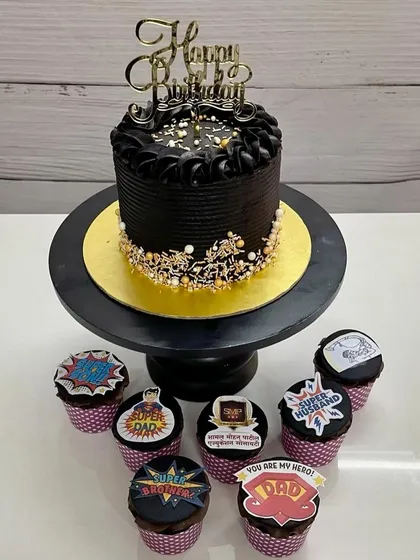 A hero's treat. This combo of a rich black birthday cake and "Super Dad" themed cupcakes is perfect for the man who plays every role in your life.