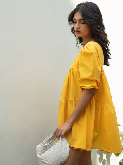 A simple and chic side-profile shot for Itgirl Love. This image clearly shows the silhouette and tiered design of the yellow summer dress, making it a useful photo for online shoppers.