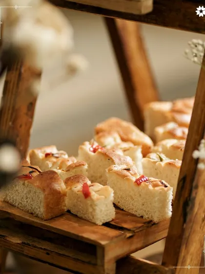Freshly baked focaccia bread, cut into squares for easy sharing. We believe in the power of simple, well made food to bring people together.