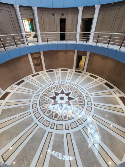 Looking down from the upper level of the Arihant Aspire clubhouse. This perspective shows the beautiful geometric patterns of the marble inlay flooring, which serves as a centerpiece for the entire rotunda.