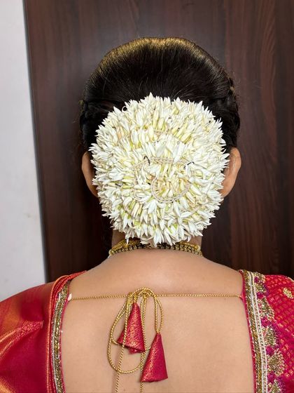 The beauty of fresh mallige flowers. Here, they are perfectly wrapped around a classic bun, creating a fragrant and timelessly elegant hairstyle for a traditional South Indian look.