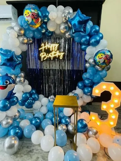 I bring popular kids' themes to life, like this Baby Shark decoration for a 3rd birthday. This party setup features a circular balloon arch, a light-up number '3', character balloons, and a modern "Happy Birthday" neon sign.