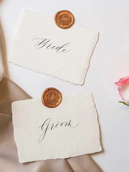 The elegance of modern calligraphy is perfect for weddings. These "Bride" and "Groom" place cards with wax seals are a beautiful example of how this script adds a touch of class.