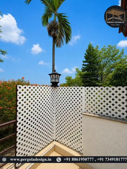 We also craft elegant privacy solutions. This white lattice panel, complemented by an outdoor lamp, provides a decorative screen for a balcony or terrace, ensuring privacy without completely blocking light or airflow.