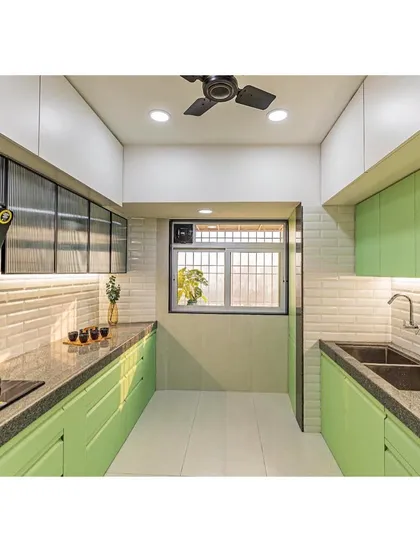 A fresh and modern kitchen design featuring calming pistachio green cabinetry and a clean, white-tiled backsplash. We designed this parallel kitchen for maximum efficiency, with ample storage and well-lit countertops for a delightful cooking experience.