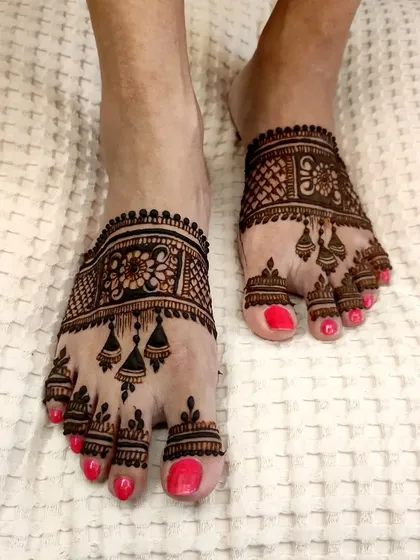 A lovely feet design with hanging jhumka motifs, perfect for festivals like Diwali. It's detailed but not as heavy as a full bridal design.