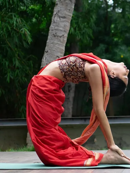 This is the Ustrasana, or Camel Pose, a deep backbend that opens up the chest and improves spinal flexibility. I love how practicing yoga in a saree connects me to my roots while I flow.