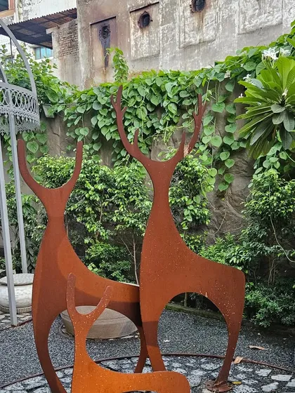 The right art piece can completely transform a garden. These stylized deer sculptures, crafted from weather-resistant corten steel, add a touch of modern elegance to this landscaped corner.