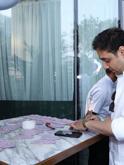 A guest carefully writing his wishes on a butterfly card. These personal touches create a heartfelt atmosphere.