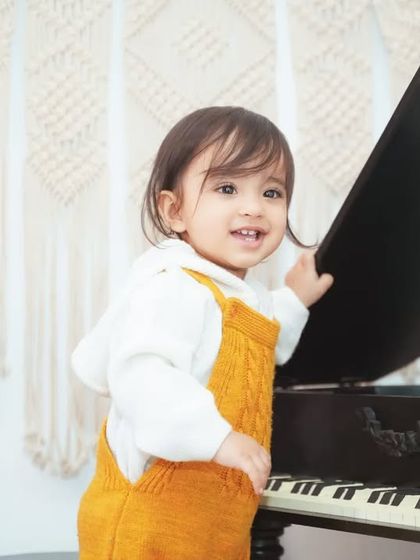 A playful moment at the mini piano. Our studio is full of interactive props to keep your little one engaged and happy.