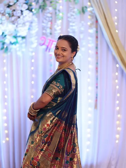 A candid shot of the client at the event, with her hair tied in a simple, elegant bun with a flower.