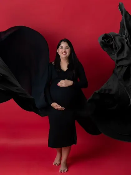 A duplicate of image 3, a powerful solo maternity portrait against a vibrant red background.