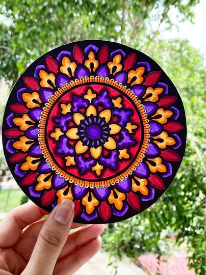 This circular mandala is filled with a vibrant mix of purple, orange, and red hues. I created this piece on a black acrylic sheet, which makes the colors appear especially rich and deep.