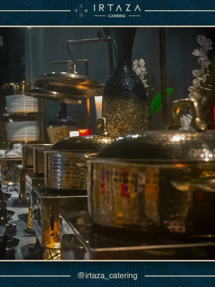 A low-angle shot of my hammered gold chafing dishes, reflecting the ambient light of the event. This perspective highlights the quality and shine of the serveware I use to ensure your event looks and feels premium.