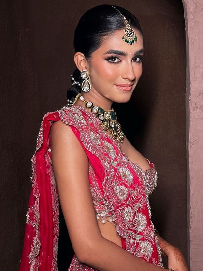 A profile view of this beautiful bride, showcasing her sleek hair and radiant makeup. The look is a perfect example of modern Indian bridal beauty, combining tradition with contemporary elegance.