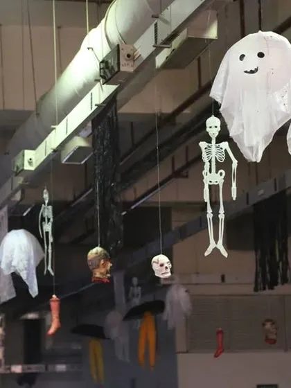 Simple yet effective Halloween decorations, like these hanging skeletons and ghosts, which I use to transform any space, including office ceilings, for a festive celebration.