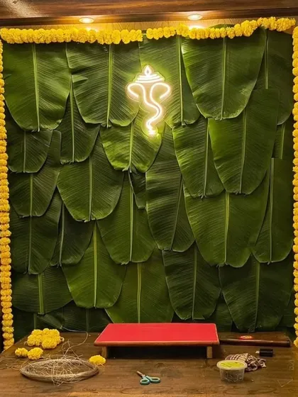 I combined tradition with a modern twist in this unique backdrop. A wall of fresh banana leaves is accented with a neon light Ganpati silhouette and framed with yellow marigold garlands for a truly one-of-a-kind look.