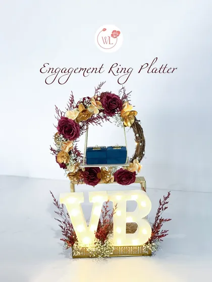 Make the proposal unforgettable with a personalized engagement ring platter. This design features a floral wreath, two velvet ring boxes, and custom light-up initials, creating a magical and romantic setting for the big question.