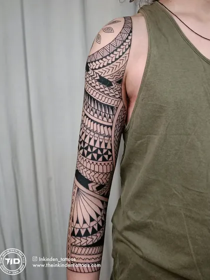 The side view of a completed Maori sleeve, displaying the seamless wrap-around design. The balance between dense blackwork and detailed patterns is key to creating a visually striking and authentic piece.