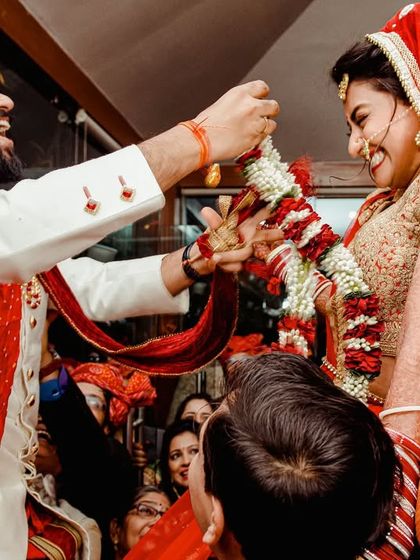 A joyful, high-energy moment from a Varmala ceremony, where the couple exchanges garlands. This is a duplicate of 69, but it fits perfectly here.