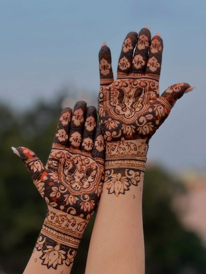 The beautiful, rich stain of the dulha-dulhan mehendi, captured against a natural outdoor background.